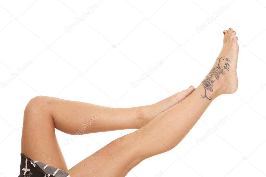 Woman legs crosses tattoo lay feet up