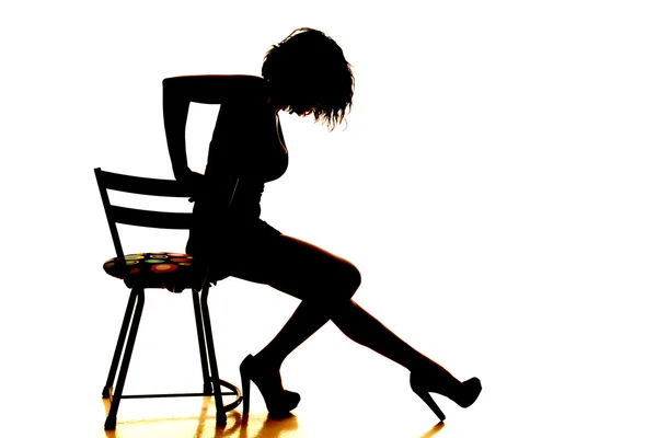 Silhuett kvinna sitter benen ut — Stockfoto