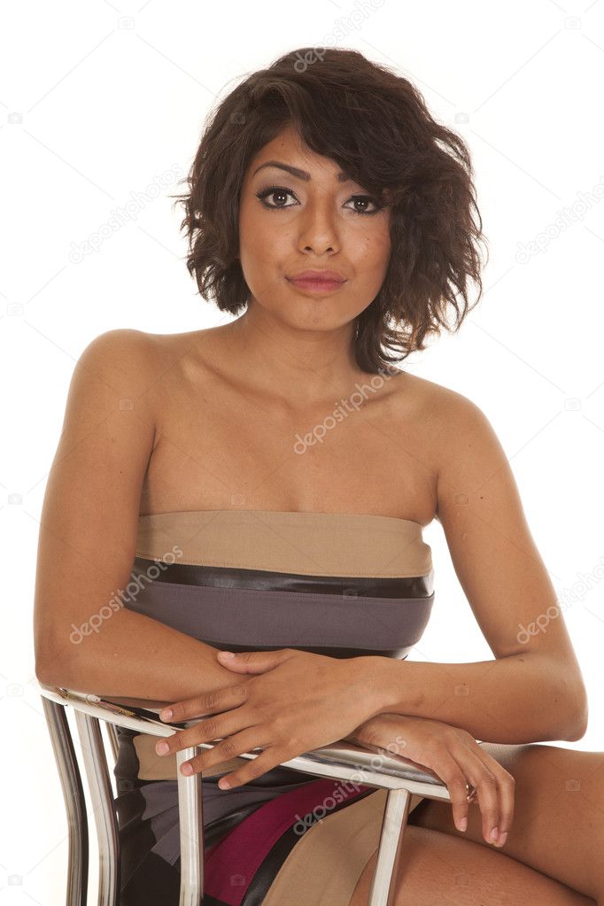 Hispanic woman close sitting in a dress serious