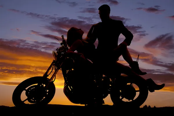 Vrouw leg terug op de motorfiets man stand silhouet Rechtenvrije Stockfoto's