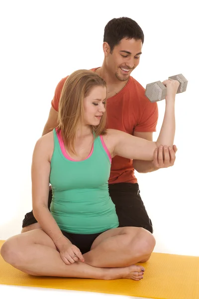 Frau sitzt Mann hinter Hilfe wirft Gewichte — Stockfoto