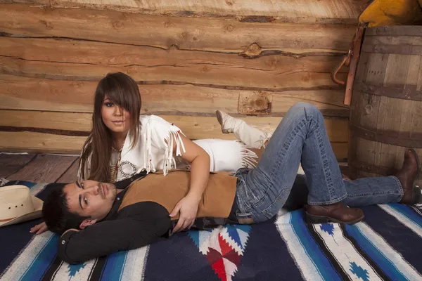 Cowboy and Indian woman laying both looking — Stock Photo, Image