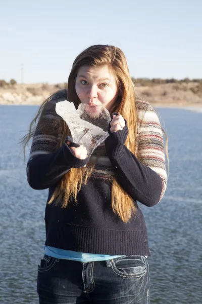 Chica chupando en un gran pedazo de hielo en congelado lago —  Fotos de Stock