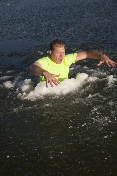 Homme dans le trou de glace chemise verte mains dehors — Photo