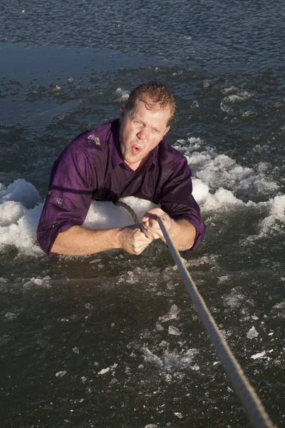 Hombre en agujero de hielo tire de la cuerda fría — Foto de Stock