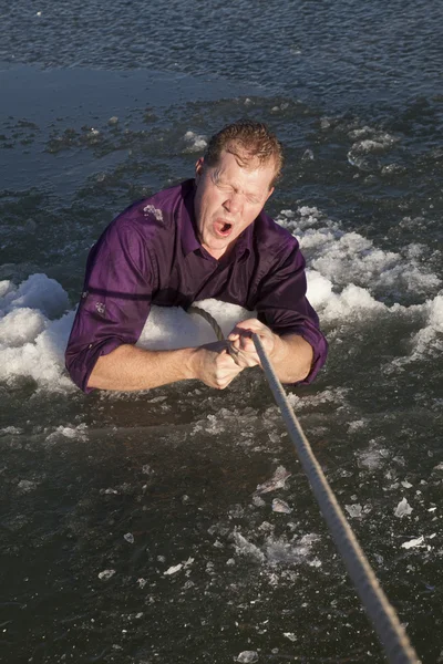 Hombre en agujero de hielo tire hacia fuera en la boca de la cuerda abierta — Foto de Stock