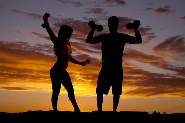 Silhouette couple with weights flex — Stock Photo, Image