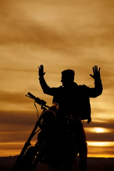 Silhouette of a man on a motorcycle hands up — Stock Photo, Image