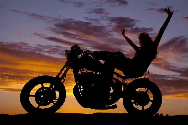 Silhouette woman on a motorcycle arms in air — Stock Photo, Image