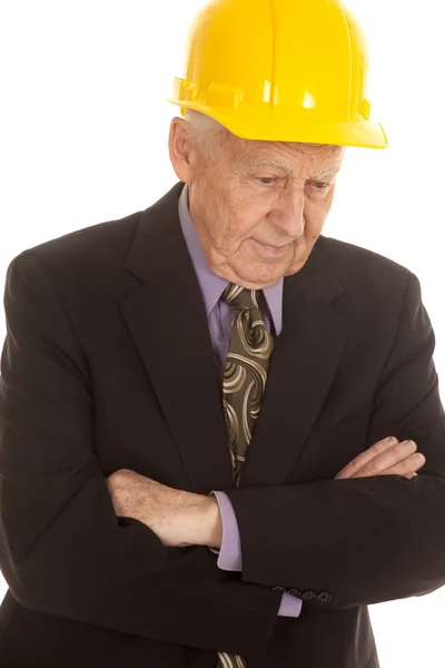 Uomo anziano vestito hardhat braccia piegate guardare giù — Foto Stock