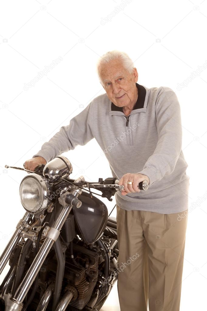 Elderly man holding motorcycle handlebars