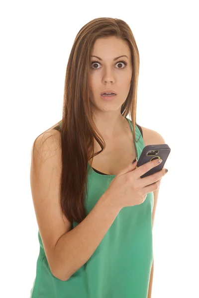 Vrouw in groene top met telefoon schok kijken — Stockfoto