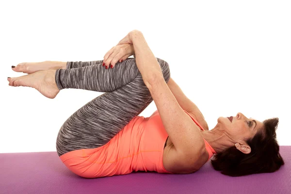 Older woman yoga on back curl knees — Stock Photo, Image