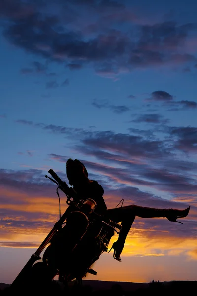 Silhouette woman on motorcycle leg up head back side. — Stock Photo, Image