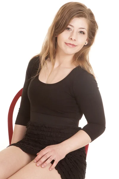 Женщина черное платье красный стул близко взгляд — стоковое фото