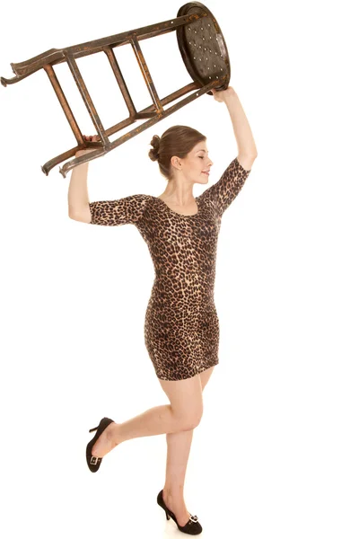 Woman leopard dress hold chair up leg up — Stock Photo, Image