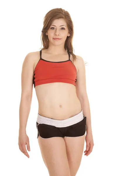 Mulher shorts e vermelho esportes sutiã stand — Fotografia de Stock