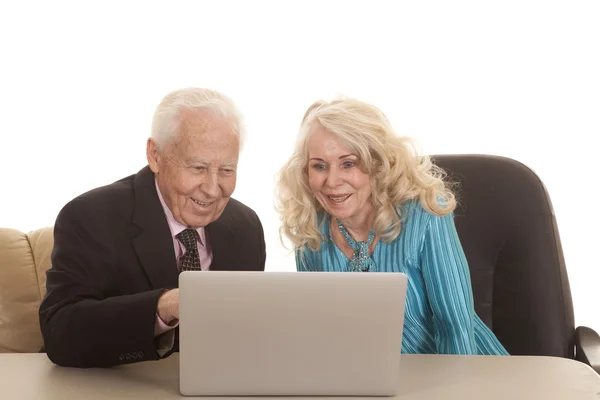 Bejaarde echtpaar laptop die beide glimlach — Stockfoto