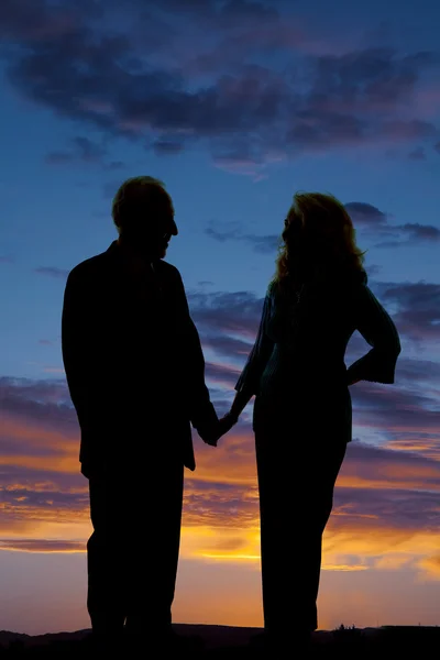 Anziani coppia silhouette tenere per mano — Foto Stock
