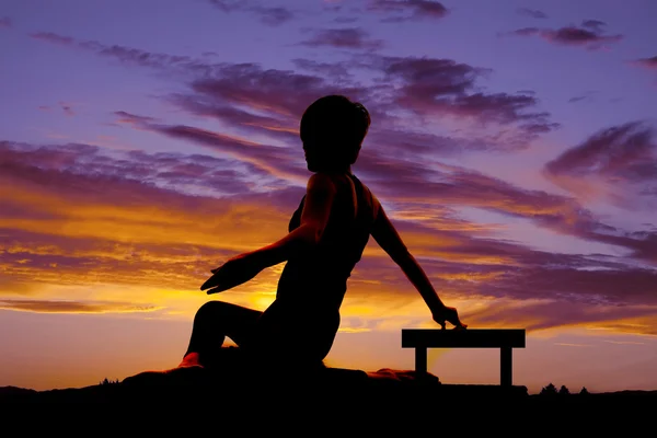 Sylwetka kobiety siedzieć skręt zachód słońca — Zdjęcie stockowe