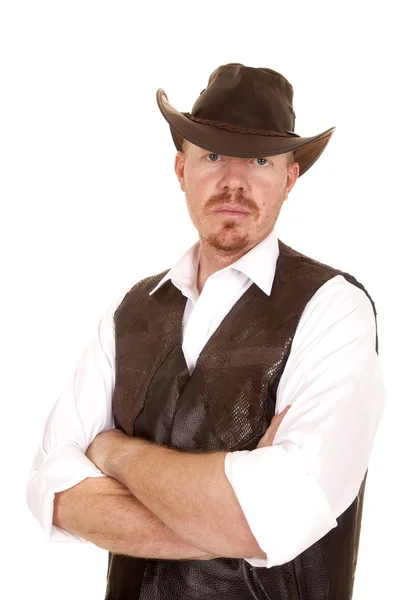 Cowboy in vest and hat arms folded looking serious — Stock Photo, Image