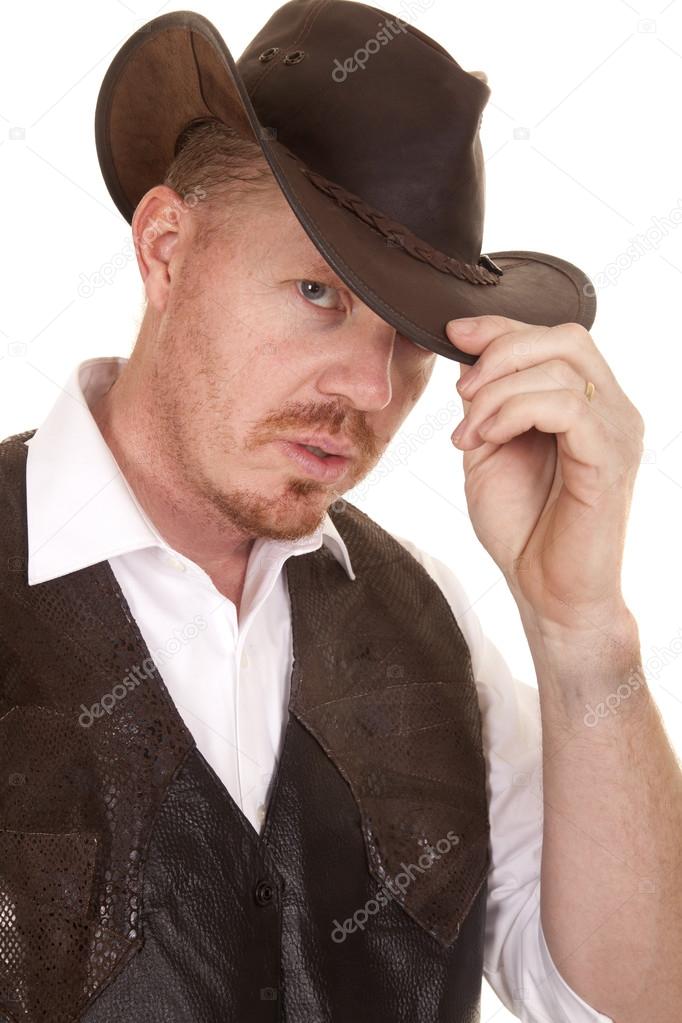 Cowboy close vest hand on hat serious