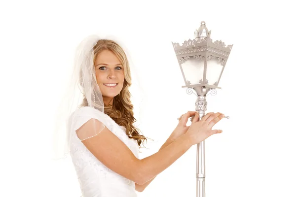 Woman wedding dress lamp post hold — Stock Photo, Image