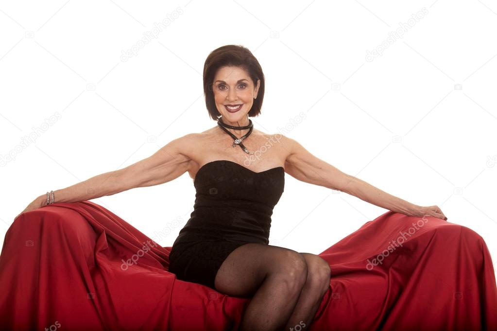 older woman black dress sit on red arms out