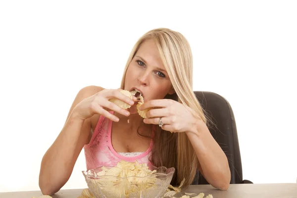 Vrouw roze tank top chips eten veel — Stockfoto