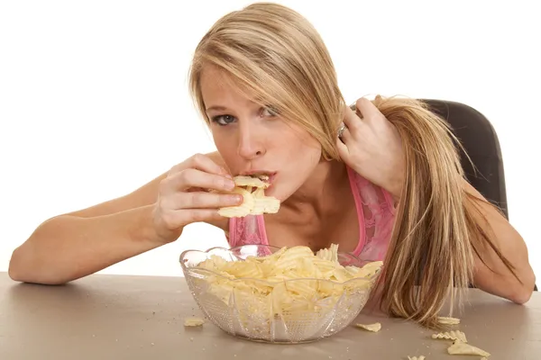 Mujer rosa tanque superior chips inclinarse sobre comer —  Fotos de Stock
