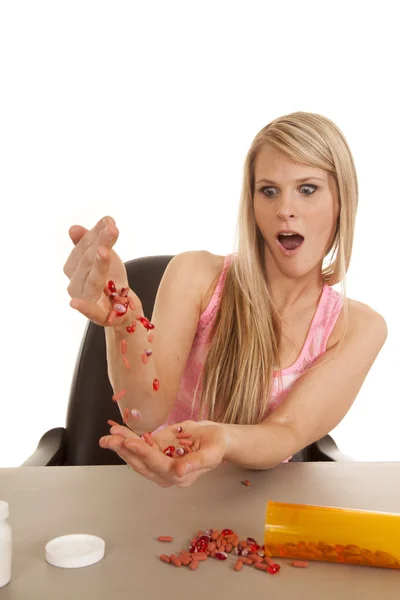 Woman pink tank top pour pills between hands — Stock Photo, Image