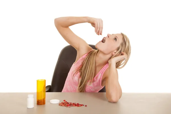Mulher rosa tanque top pílulas cair na boca — Fotografia de Stock