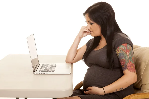 Gravid kvinna med laptop tror — Stockfoto