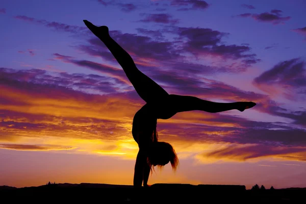 Silhouette of woman dancing on hands legs up out — Stock Photo, Image