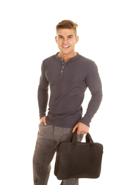 Man grijs lange mouw shirt stand houden zak glimlach — Stockfoto