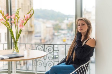 Kafeteryada kitap ya da dergi okuyan beyaz bir kız. Serbest meslek, iş kavramı. Sabah rutini.