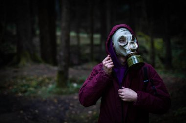 Ekolojik felaket. Gaz maskeli kıyamet sonrası hayatta kalanlar. Ormandaki adam.
