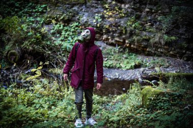 Ekolojik felaket. Gaz maskeli kıyamet sonrası hayatta kalanlar. Ormandaki adam.