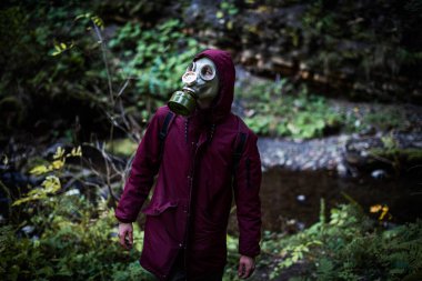 Ekolojik felaket. Gaz maskeli kıyamet sonrası hayatta kalanlar. Ormandaki adam.