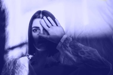 Yüzünde ve vücudunda çizgiler şeklinde gölge desenleri olan güzel bir genç kızın portresi. Moda, güzellik. 2022 Yılı Rengi