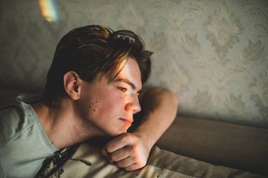 Gözlerinde gökkuşağı gölgesi ve gülümseyen tırnak boyası olan bir adam. LGBT konsepti. Gençlerin sorunları, üzgün çocuk, cilt problemi..