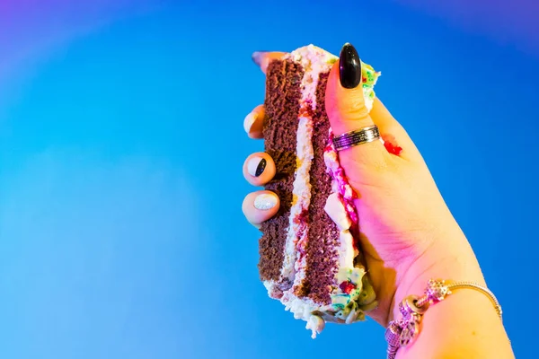 女性的手与珠宝 银质保存一块蓝色或紫色背景的乳酪蛋糕 祝你双休日快乐派对理念大旗 — 图库照片