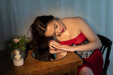 Kız moda portresi aynaya bakar. Kırmızı dudaklı çekici, genç bir esmer. Kadın özgüveni, saygısı ve güveni. Kendine inan. Estetik ameliyat, güzellik, makyaj