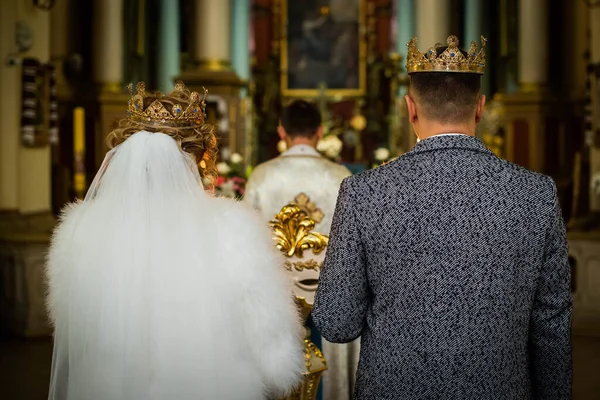 Gelin ve damat kilisedeki düğün töreninde. Gelin ve damat kilisedeki düğün töreninde ayine hazırlanıyor. Çift taç takıyordu. Yunan Katolik veya Ortodoks Kilisesi.