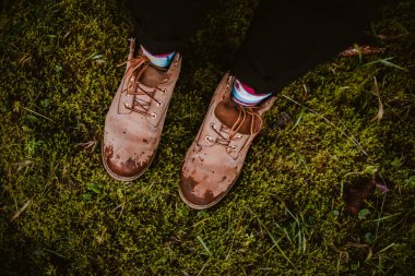 Bacakları, pantolonları ve sonbahar ormanındaki ağaç kütüğünde kahverengi deri çizmeleri vardı. Islak ayaklar, yolculuk, soğuk, soğuk, tehlikeli