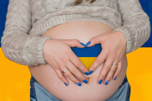 ウクライナでの戦争や難民の概念への人道援助はない 心の形をしたウクライナの旗を描いた女性の妊娠中の腹 — ストック写真