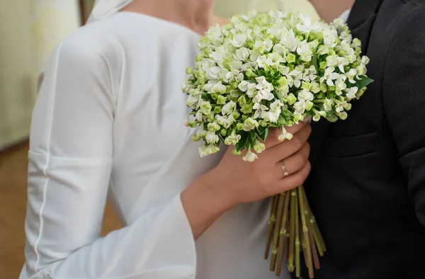 身着白衣的新娘紧盯着新郎 用一束鲜花拥抱着新郎 婚戒近景 — 图库照片