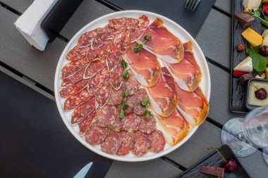 Et tabağı. Çeşitli sosisler ve etler. Meyve, et ve peynir çeşitleri masada. Nefis yemekler.