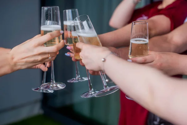 friends clink champagne glasses. Bride with jewelry and wedding ring