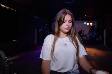 young girl in a white t-shirt at a party. teenage bad habits